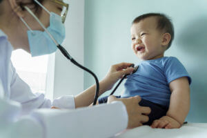 Pediatrician doctor examining smiling Baby