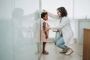 Child at physical appointment measuring height