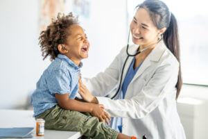 pediatrician checking heart beat of a child